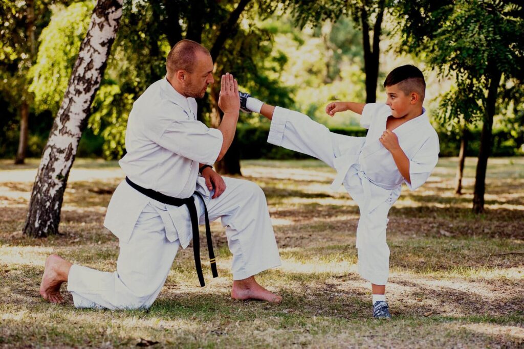 Private martial arts instructor training a kid